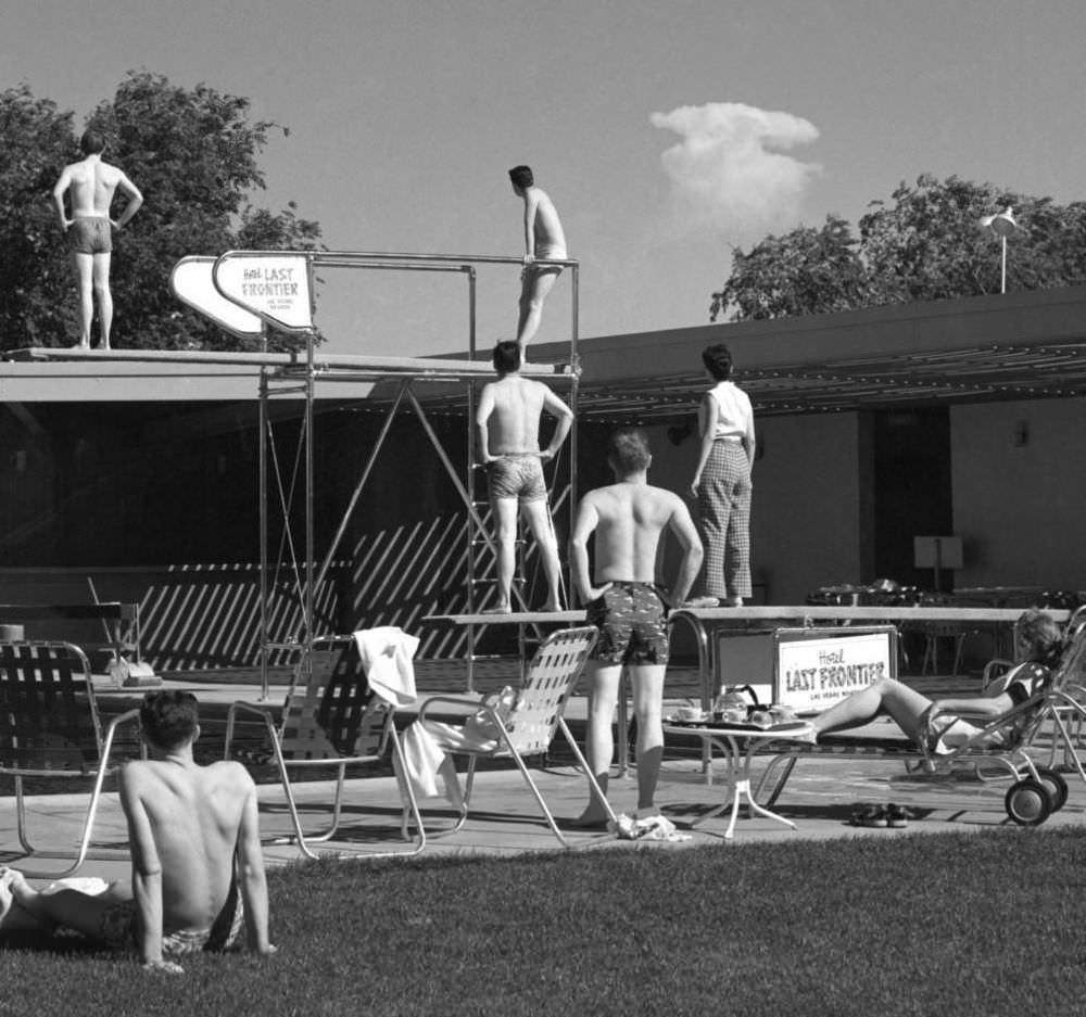 #4 Early morning bathers at a hotel pool in Las Vegas stop to watch the mushroom cloud of an atomic detonation at a test site about 75 miles from the city. May 8, 1953.