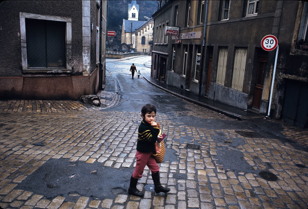 #26 Young boy walking on Rue Mohrfels about to cross Rue du Pont.