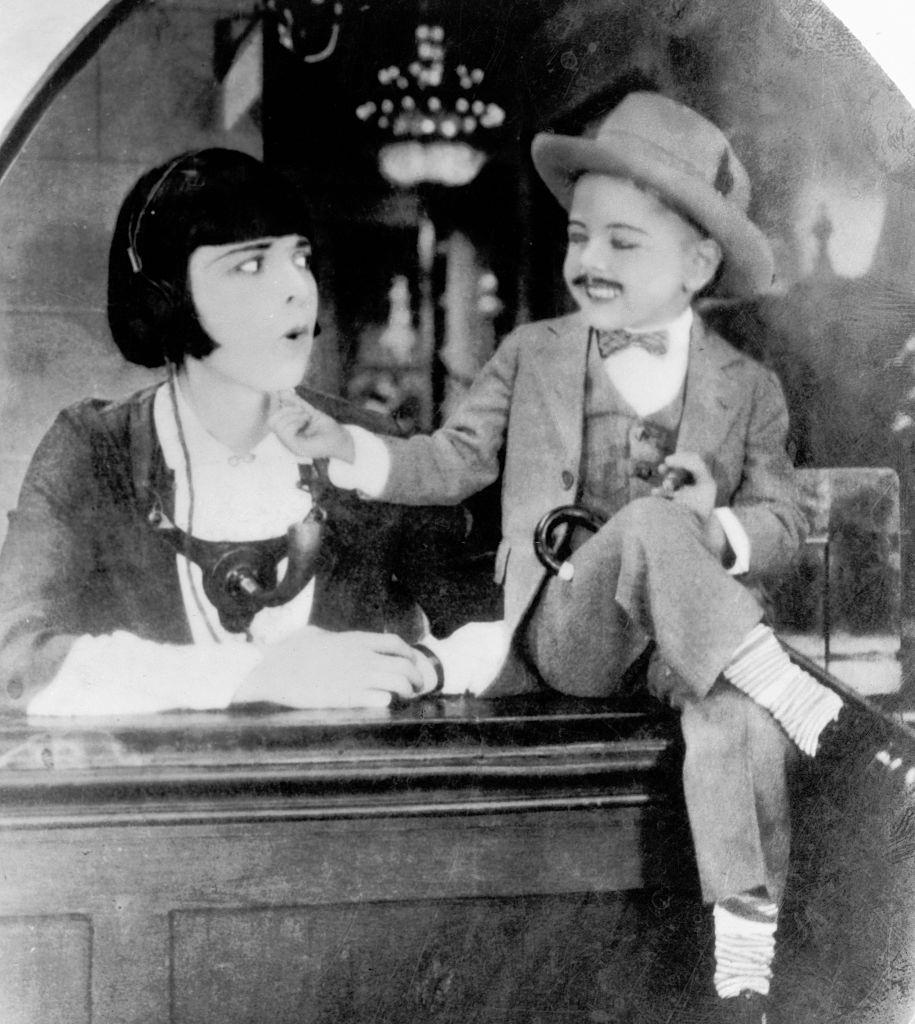 #5 A mustachioed 4-year-old Mickey Rooney tickles his co-stars chin in a silent movie, 1924.