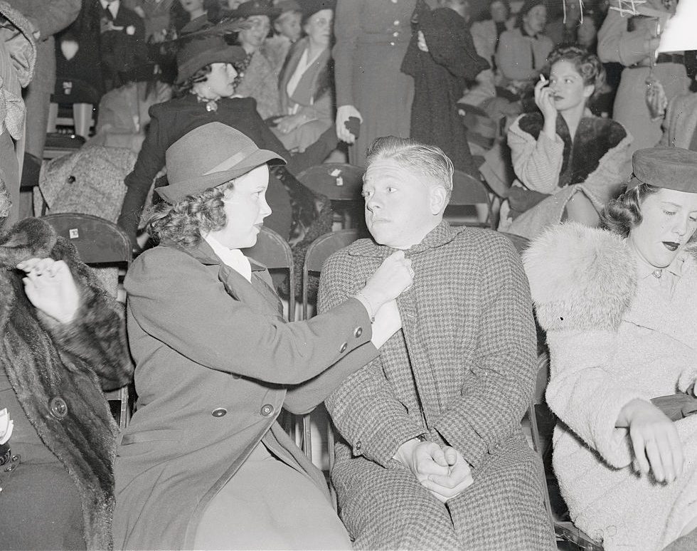 #46 Judy Garland adjusting coat of Mickey Rooney.