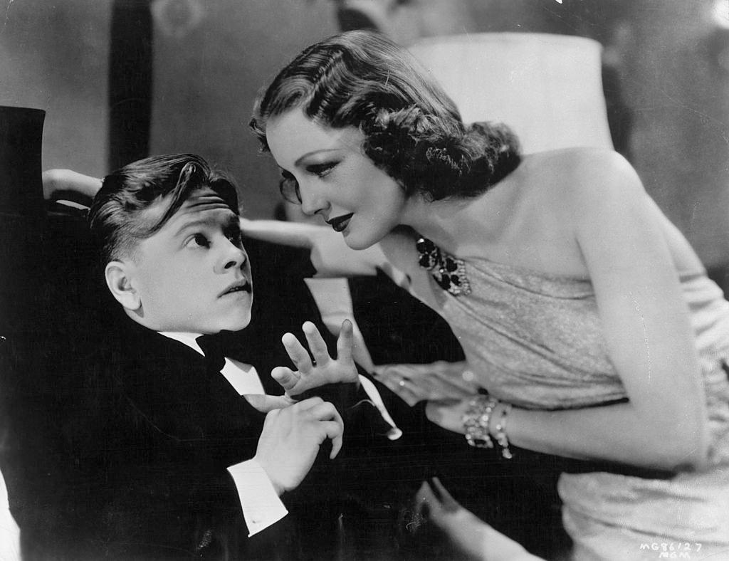 #54 Mickey Rooney is reclined as Virginia Grey leaning into him in a scene from the film ‘The Hardys Ride High’, 1939.