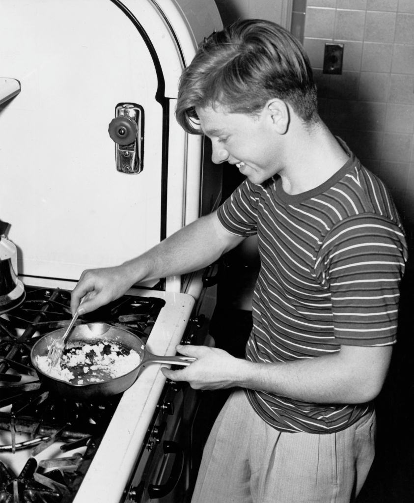 #63 Mickey Rooney cooks scrambled eggs from the hens at his San Fernando ranch, 1939.