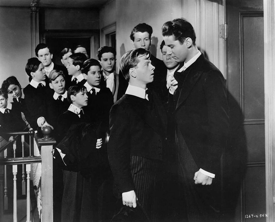 #68 Mickey Rooney pulls on the collar of Peter Lawford in a scene from the film ‘A Yank At Eton’, 1942.