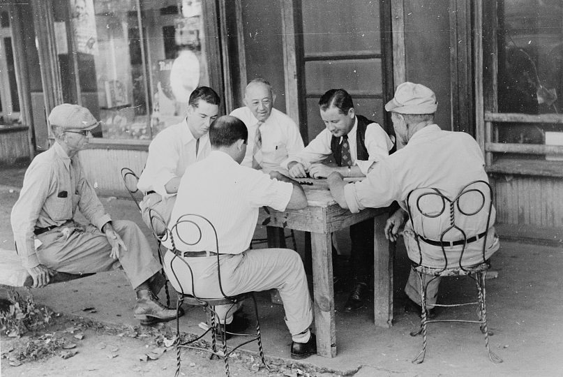 #21 Playing dominoes or cards in front of drug store in center of town in Mississippi Delta, 1939.