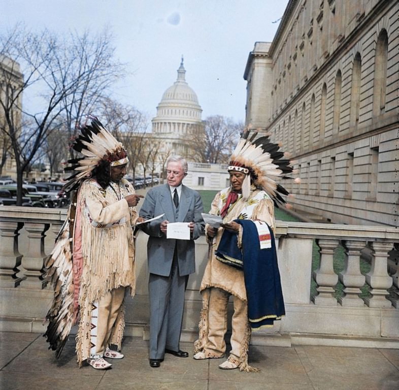 #6 Two Native American elders, dressed in traditional garb discussing policy with a member of President Coolidge’s staff.