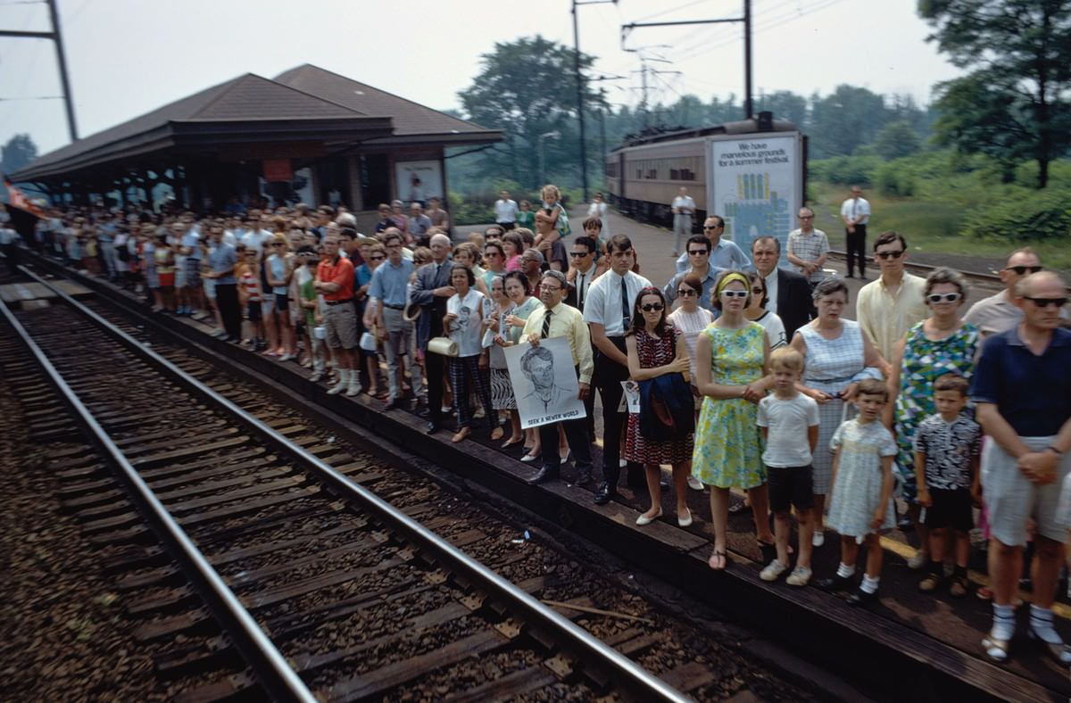 #6 The funeral train rolls through Princeton Junction, New Jersey, on June 8, 1968. Several people hold portraits of Robert F. Kennedy, including a man whose poster reads Seek a Newer World.