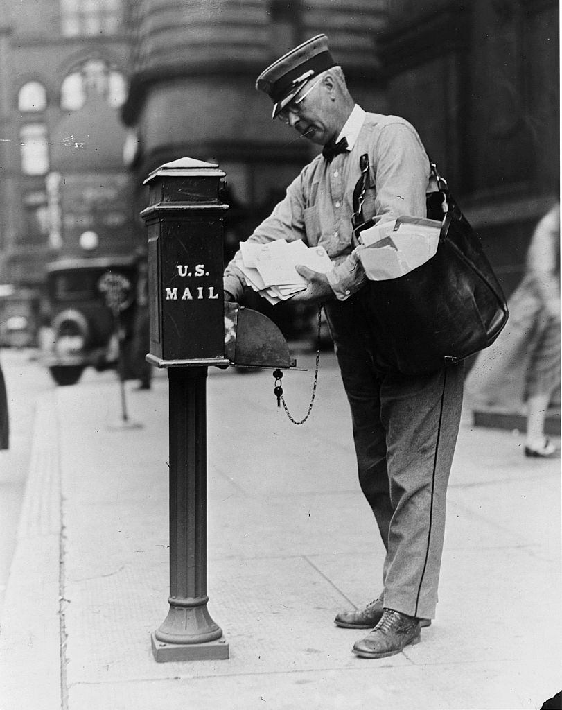 #17 Postal carrier Albert S. Dilley empties a mailbox on his downtown route. Minneapolis, Minnesota, 1930.