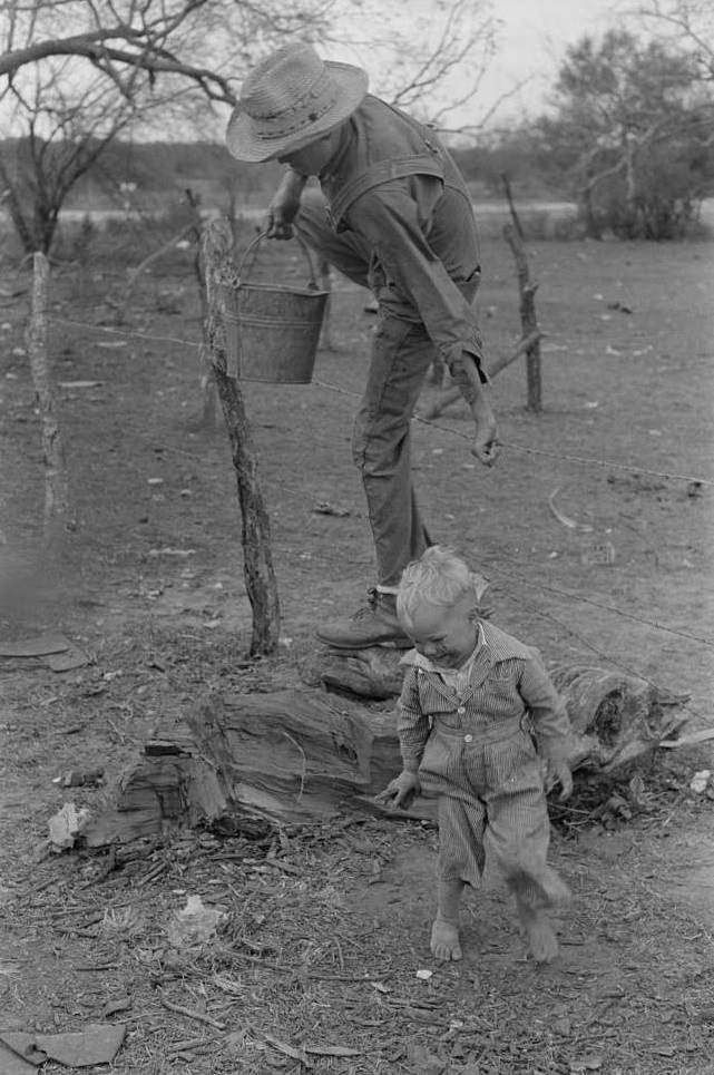 #17 Child of white migrant climbing fence with pail of water near Harlingen, Texas.