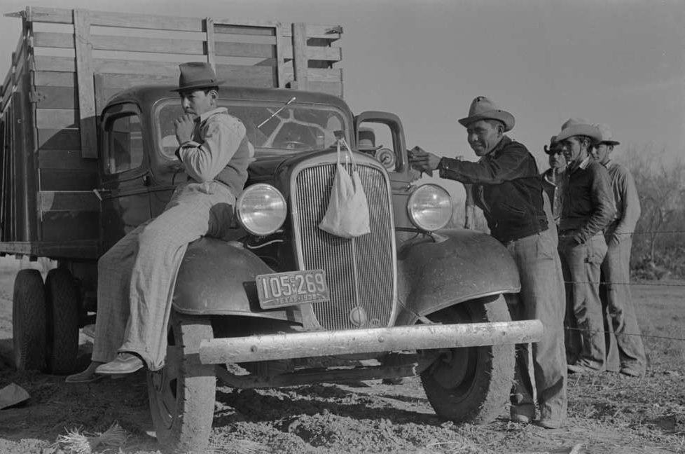 #20 Mexican carrot workers around labor contractor’s truck in field near Santa Maria, Texas, February 1939.