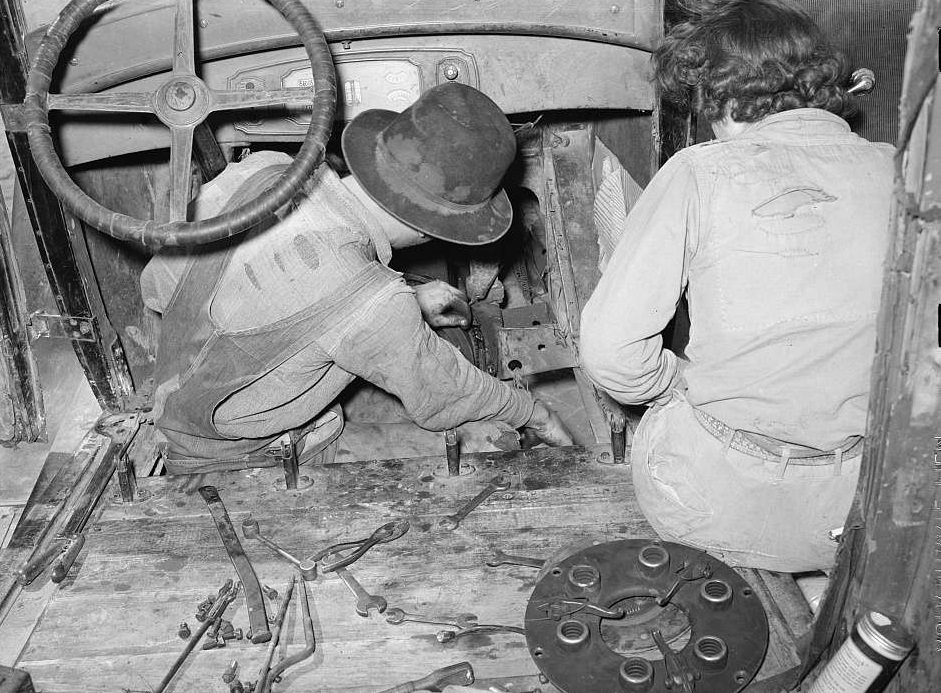 #25 White migrant and wife repairing clutch in their car near Harlingen, Texas, February 1939