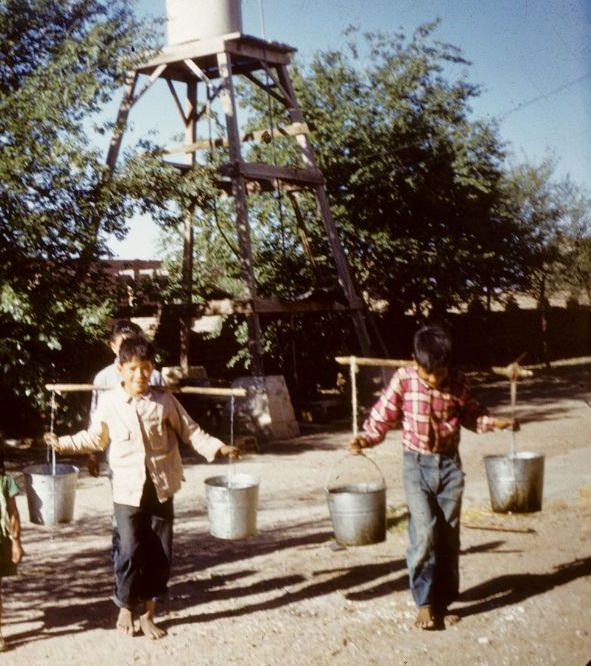 #14 Two young boys carrying water for the hospital, Cuauhtemoc, 1950s