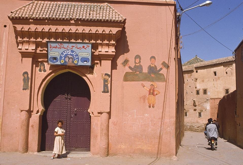 #36 A girl stands outside a building in a street in Marakesh, Morocco.