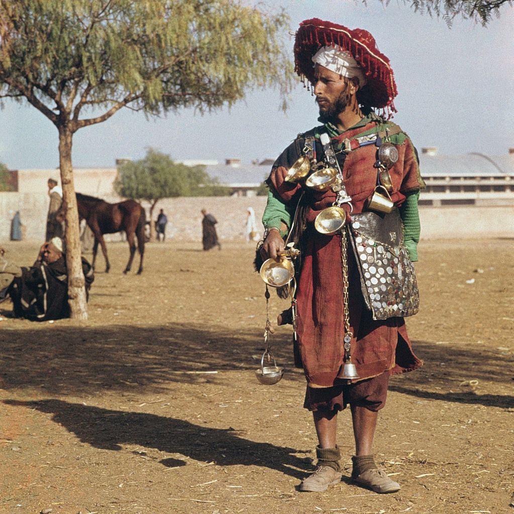 #11 A peddler sells water in traditional clothes. Marrakech, 1960.