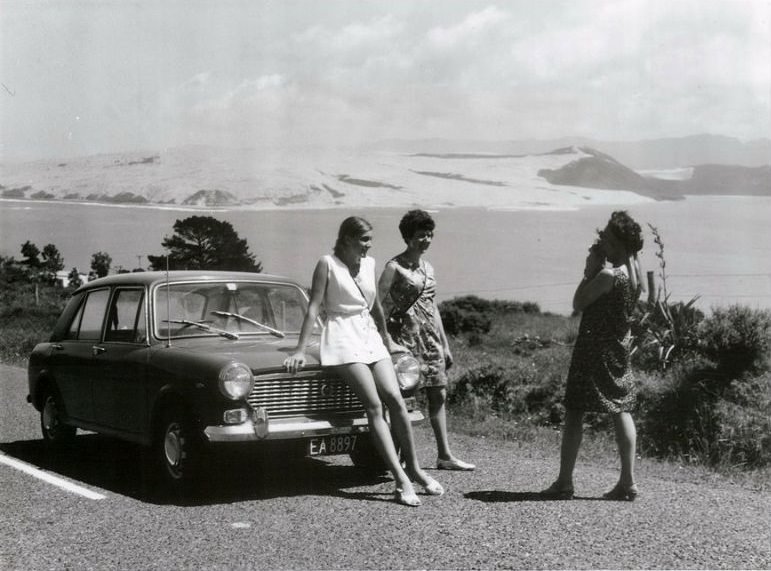 #6 Women with their a rental car stop on Omapere Hill for a photograph of Hokianga Harbour, Northland, August 1970