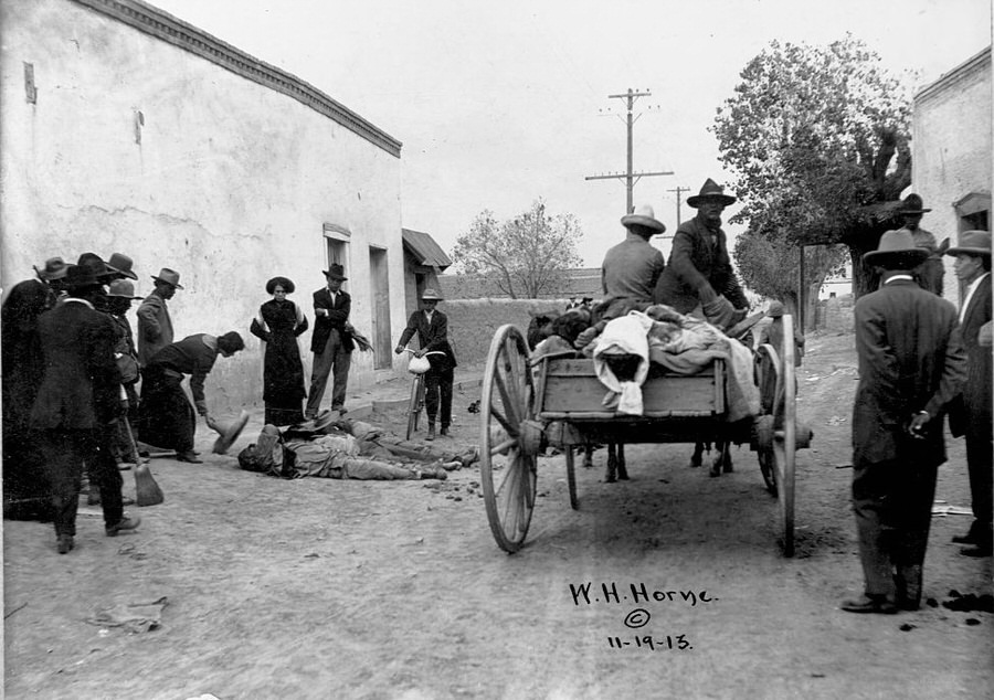 A cart of rebels collect and identify the deceased bodies in the street during the Battle of Ciudad Juasrez.