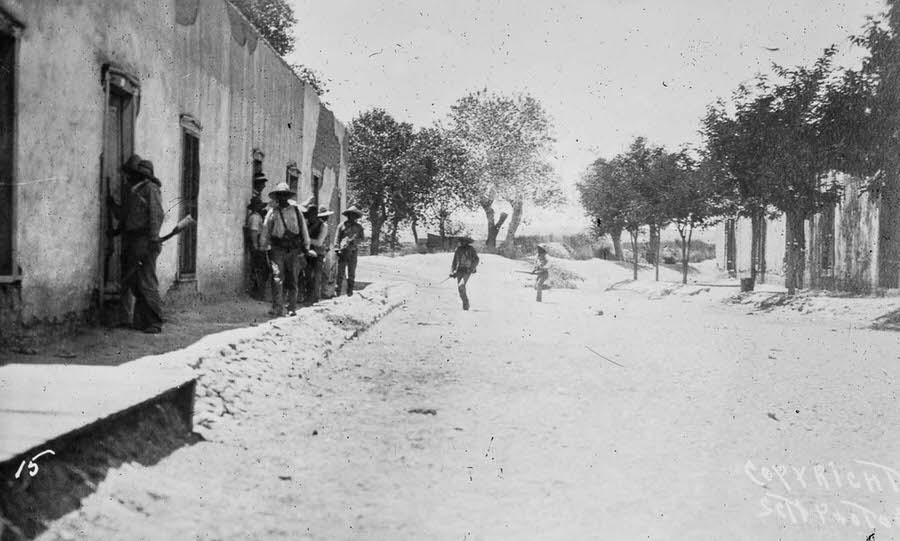 #7 Rebel fighters dash across a Juarez street under fire.