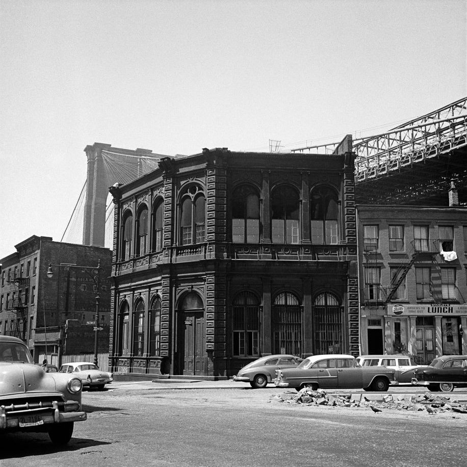 #33 The corner of Fulton and Front Streets, including the diner Stanley’s Lunch, with the Brooklyn Bridge in the background, March 1958.