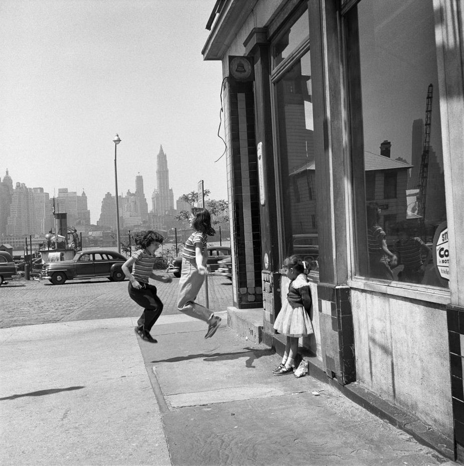 #3 Girls jump and play on Atlantic Avenue in Brooklyn Heights, March 1958.