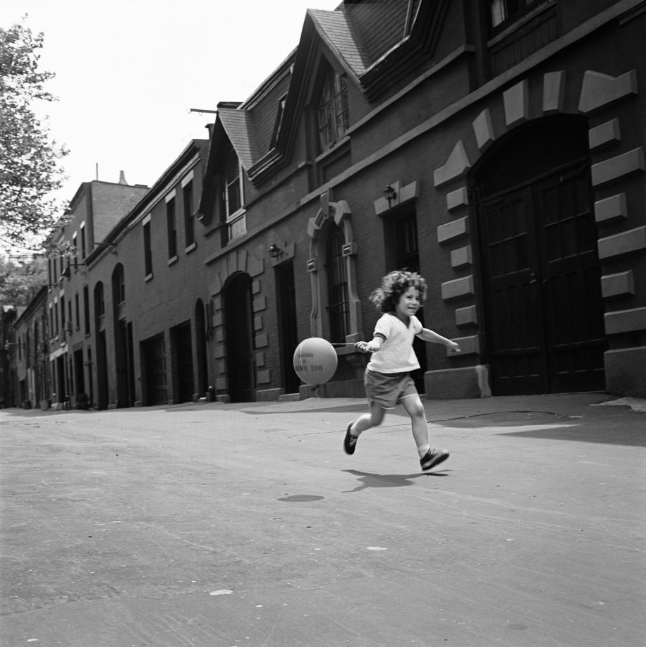 #39 A young girl runs with a balloon on Love Lane in Brooklyn Heights, March 1958.