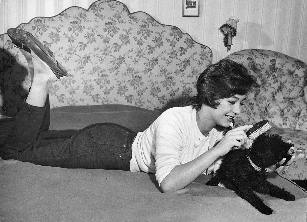 #10 Christine Kaufmann brusing her poodle, 1958.