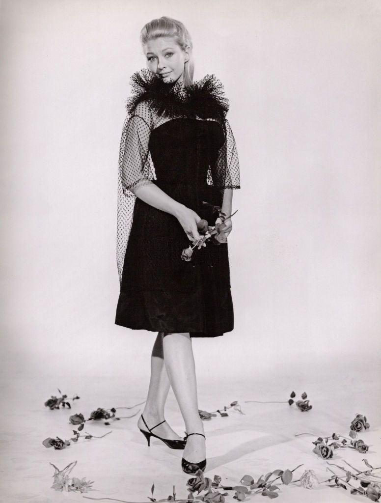 #21 Christine Kaufmann in black dress holding a rose, 1961.