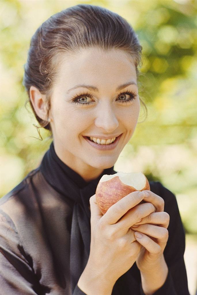 #42 Christine Kaufmann pictured eating an apple in 1969.