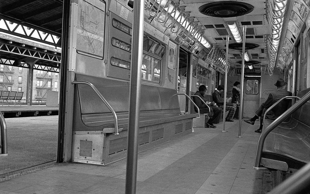 #15 A subway train sits with it’s doors open at the 82nd Street subway station in Corona, Queens as commuters enter and sit down, 1974.