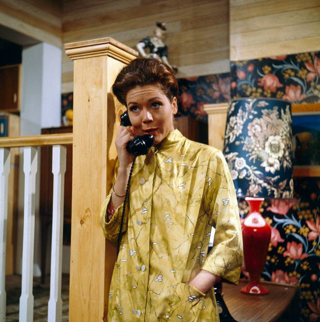 #11 Diana Rigg pictured holding a telephone receiver in a scene from the television drama ‘The Hot House’ in 1964.