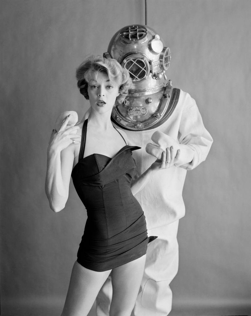 #14 Jean Patchett poses in a swimsuit with a male model in an undersea diver’s hardhat suit, 1950.