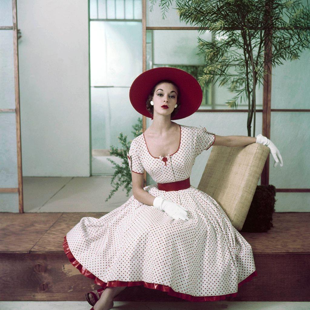 #26 Jean Patchett in red and white polka dot dress with petticoat ruffle, hat and gloves, 1952.
