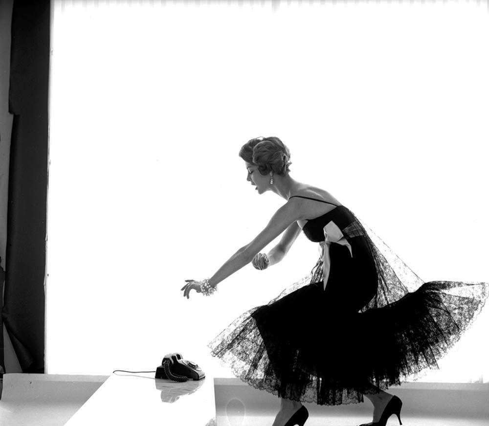 #34 Jean Patchet dressed in a black lace dress with white satin bow, 1958.