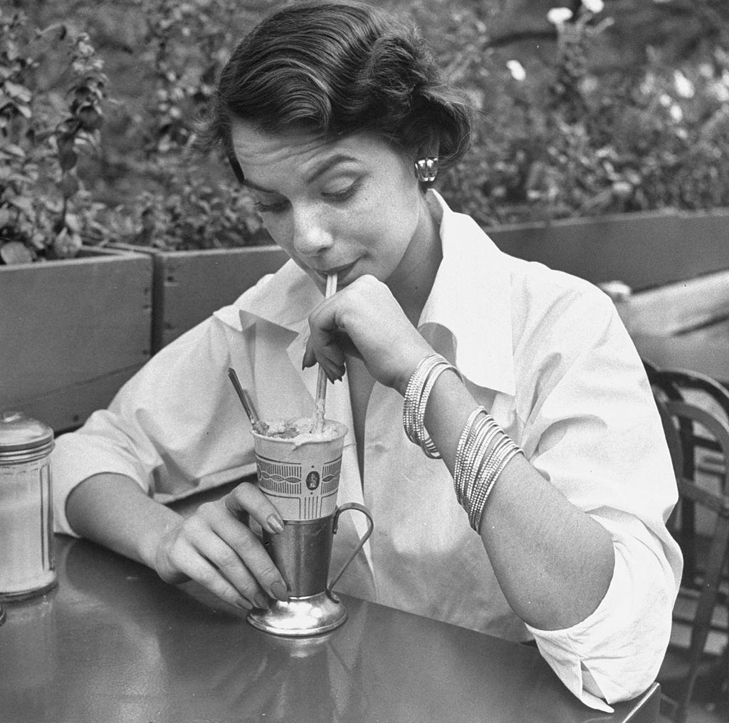#11 Jean Patchett modeling 20 braclets, at a nickel a piece, enlivening simple white shirt, 1949.