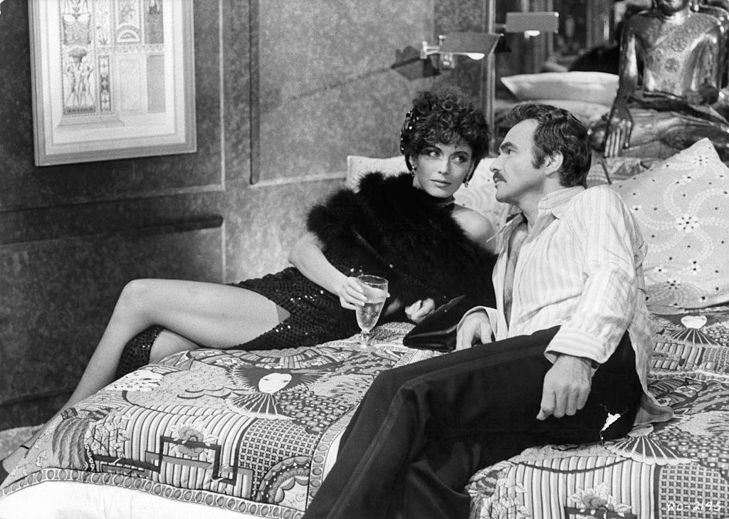 #10 Lesley-Anne Down lies down with Burt Reynolds in a scene from the film ‘Rough Cut’, 1980.