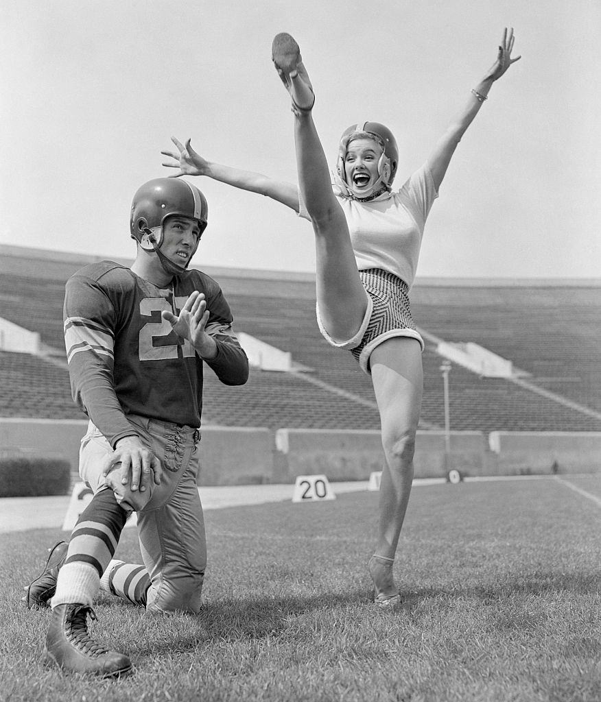 #65 Mamie Van Doren Kicking on Football Field with Jim Sears, 1953.