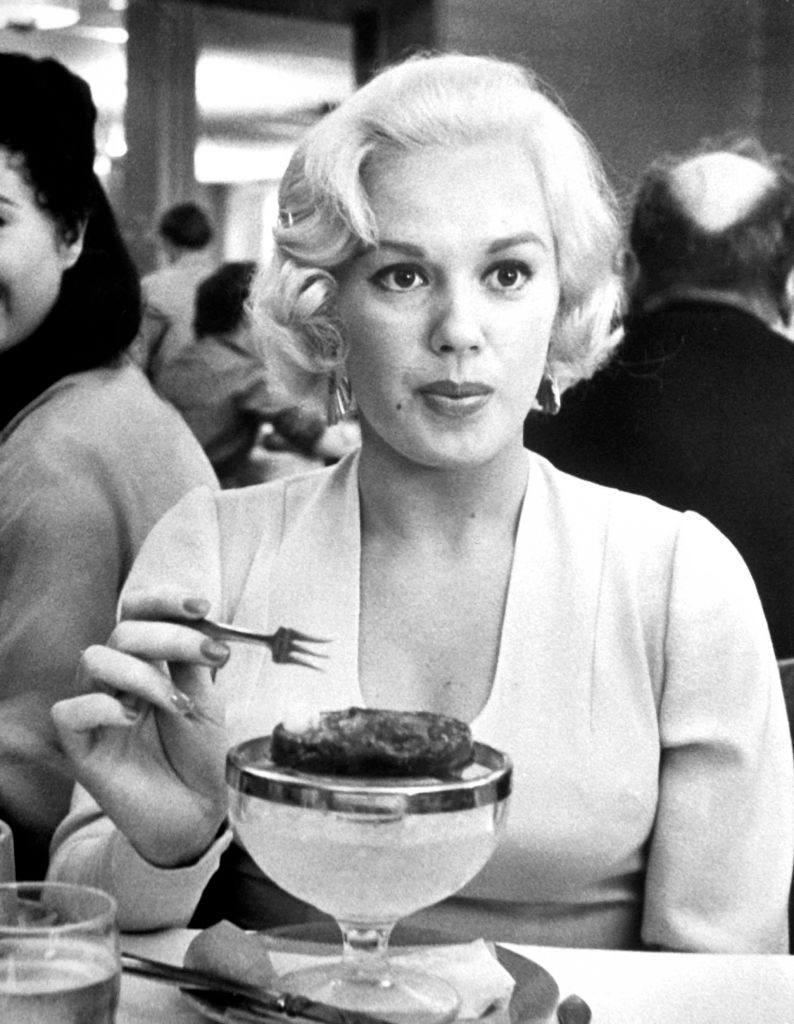 #60 Mamie Van Doren eating a frozen dessert at Universal Studios commissary, 1955.