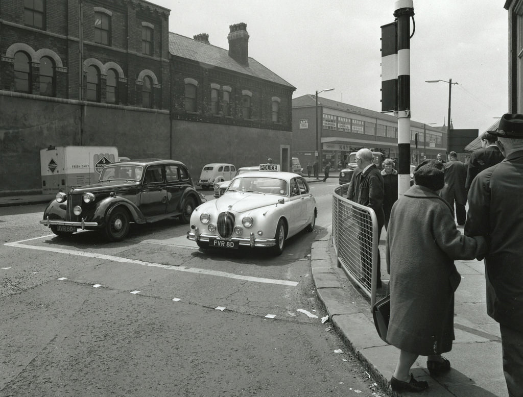 #20 A Manchester City Police Mark 2 Jaguar waits at traffic lights while being driven through longsight in the 1960s