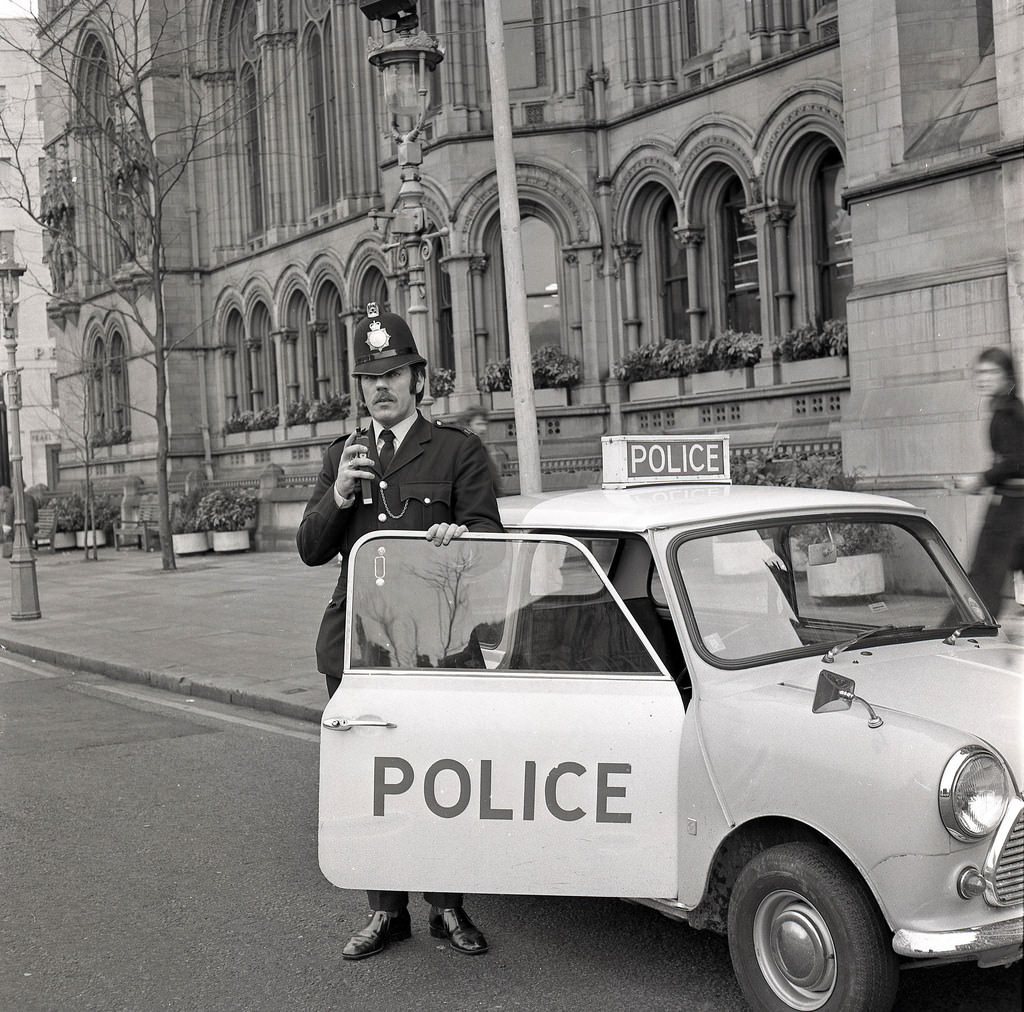 #48 A Greater Manchester Police officer parks his Mini outside the famous Manchester Town Hall in 1974