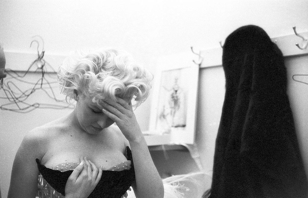 Marilyn Monroe wells up with tears of frustration because her costume doesn’t fit right in a dressing room.