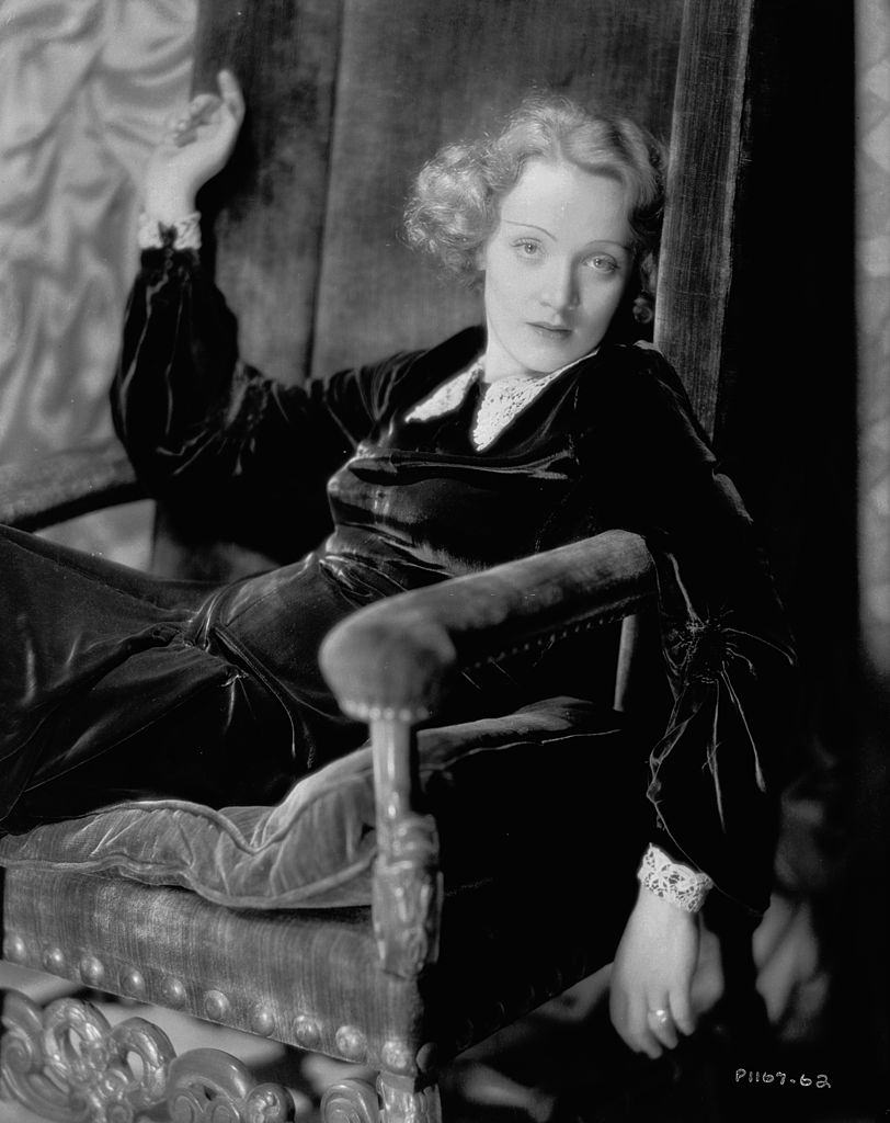 #73 Marlene Dietrich slumped into a velvet chair, 1930.