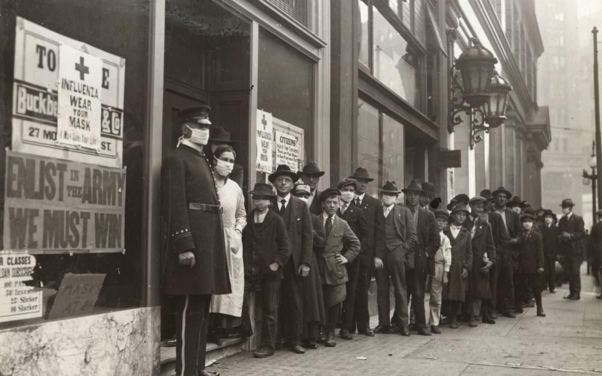 #12 People wait in line to get flu masks on Montgomery Street in San Francisco in 1918.