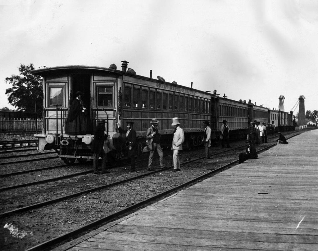 #24 Passengers board carriages of the Canadian Great Western Railway at Clifton Depot, Niagara, 1859.