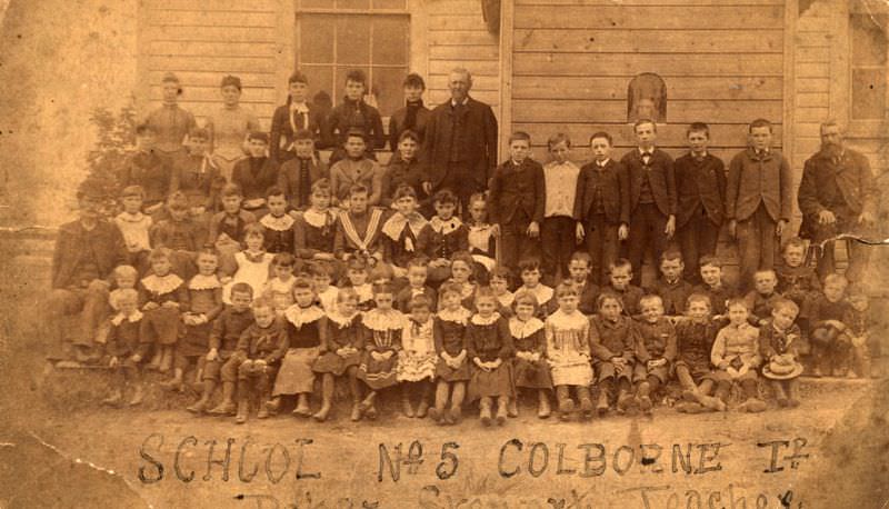 #7 Students and teachers in front of frame building, Colborne, Ontario, 1880s.