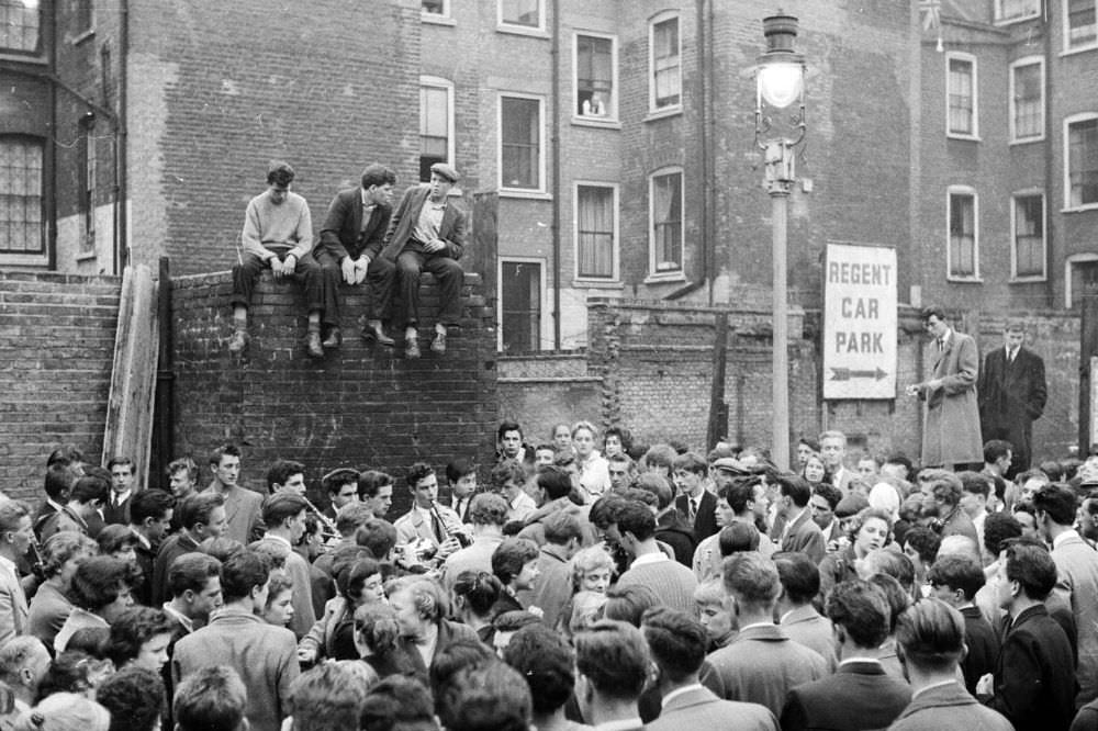 #12 London’s youth hang out on the streets of Soho in 1956.