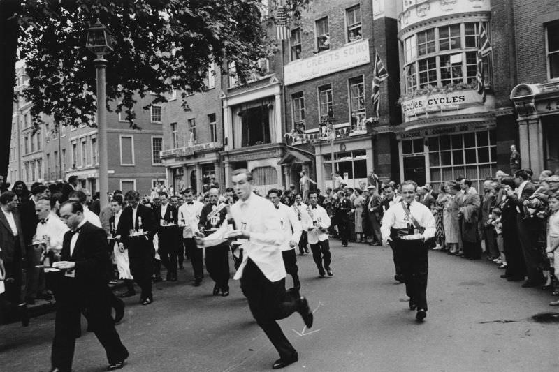 #20 Waiters carrying half bottles of champagne setting off on the annual waiters’ race from Soho Square to Greek Street, 1955.
