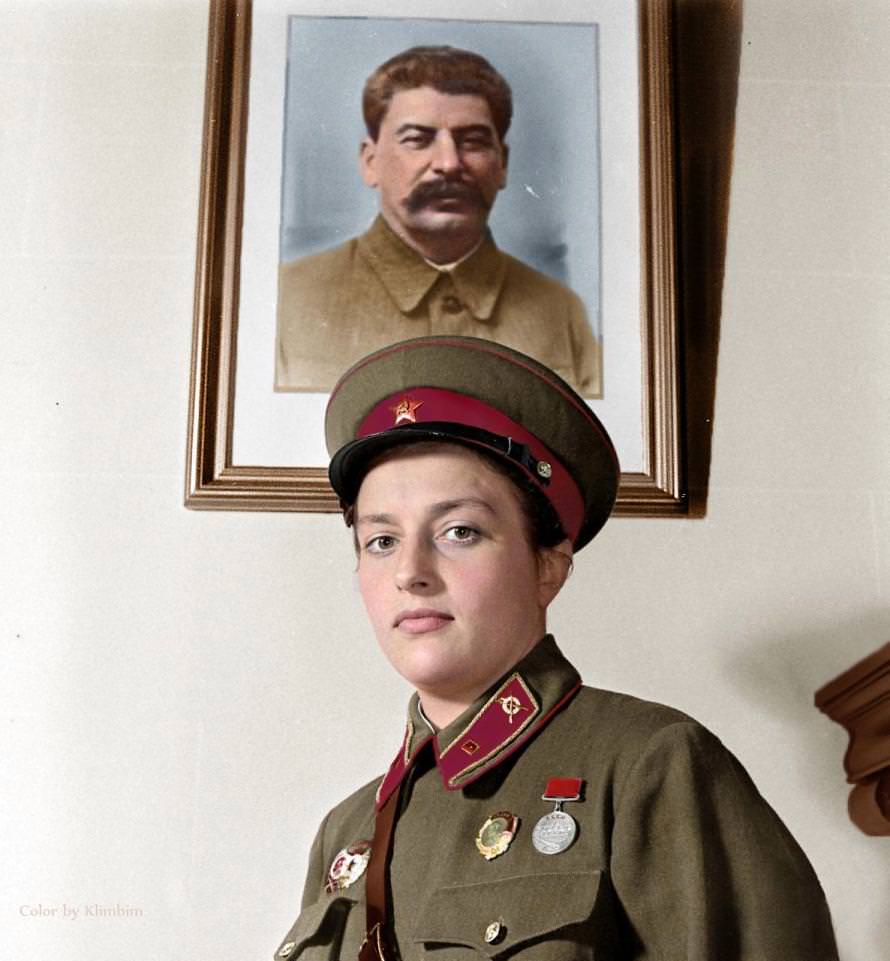 ‘Lady Death’ is pictured wearing full uniform beneath a framed picture of Soviet dictator, Joseph Stalin.