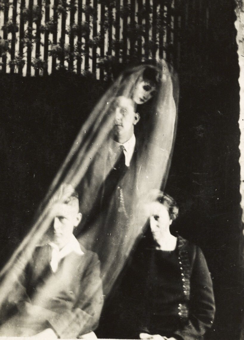 #20 A cloaked woman’s face appears over a group.
