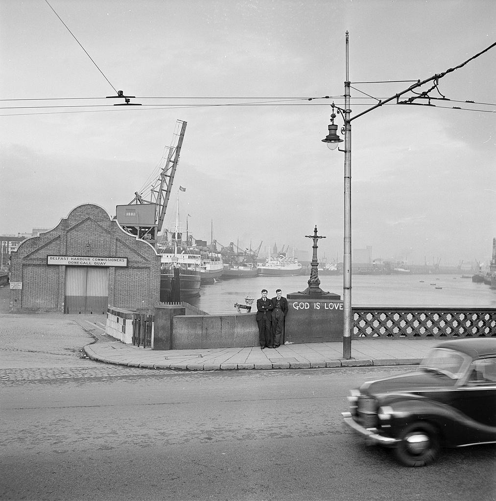 #9 Two men are leaning against the low guardrail in Belfast, 1954.