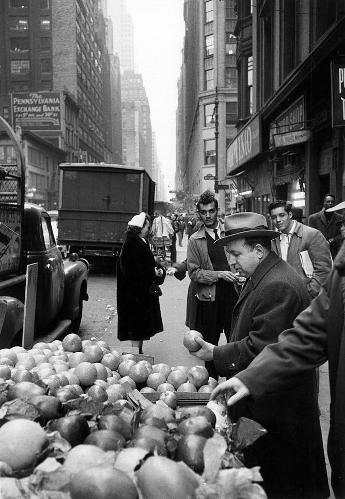 #25 An Italian-American buying some fruit on a stall in the 38th Street in Brooklyn, 1956.