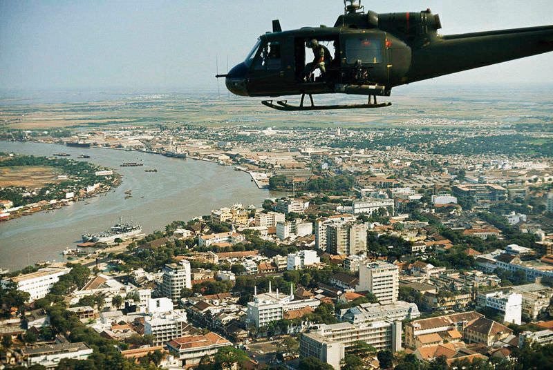 #23 An armed Bell UH-1B helicopter flies over Saigon, 1965