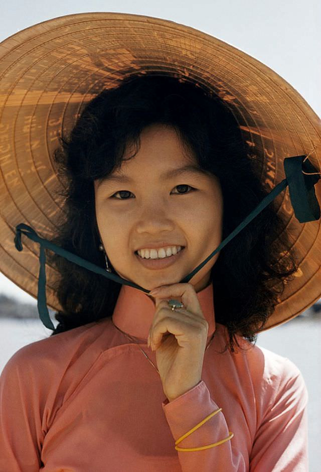 #1 An umbrellalike poetry inscribed ‘non la’, or hat, shades a girl’s face in Saigon, 1961